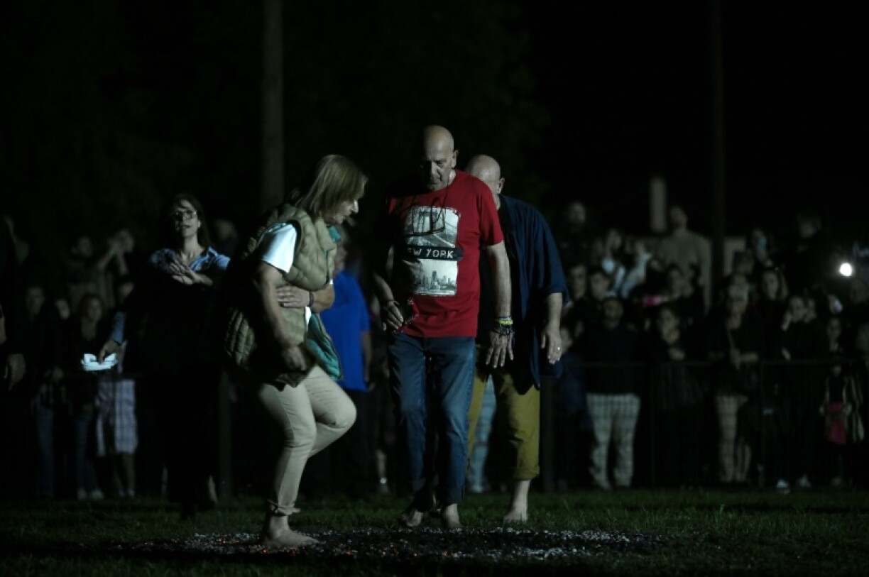 After circling the glowing embers three times, participants begin to walk on them, swaying to the music