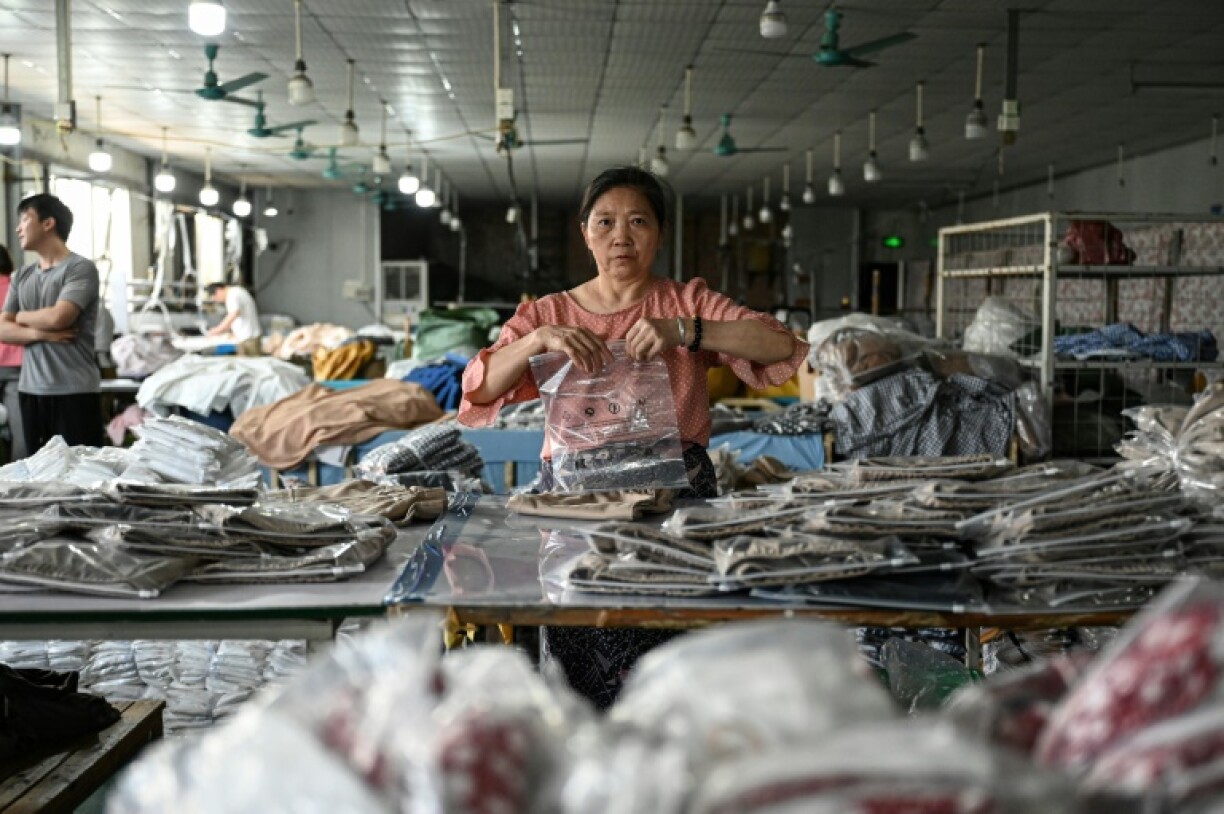 An employee packages garments for the online Chinese e-commerce company Temu at a clothing factory in Guangzhou