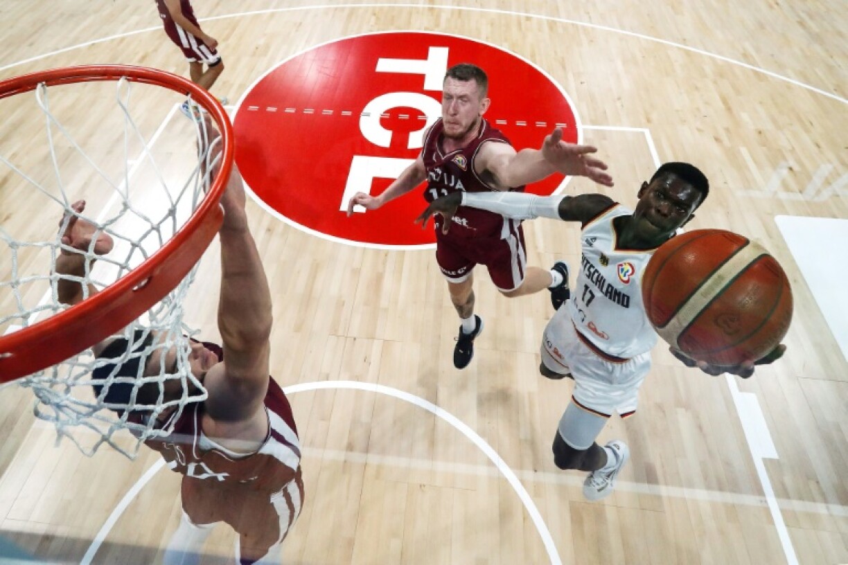 L'Allemand Dennis Schröder (à droite) au tir face aux Lettons Rolands Smits et Andrejs Grazulis (à gauche) lors du quart de finale du Mondial de basket le 6 septembre 2023 à Manille