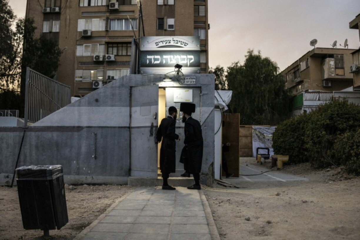 Ultra-Orthodox Jewish men walk into an underground shelter used as a prayer hall in Arad on October 1, 2026. Some secular residents have complained that some rocket shelters have been turned into prayer rooms, reducing their availability during emergencies.