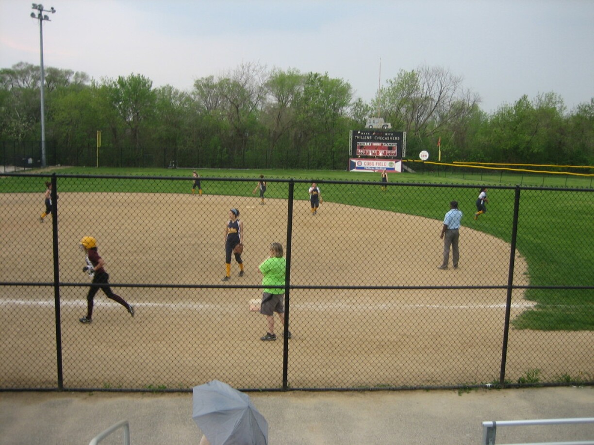 Playing baseball on Thillens field with the Thillens scoreboard in the background.