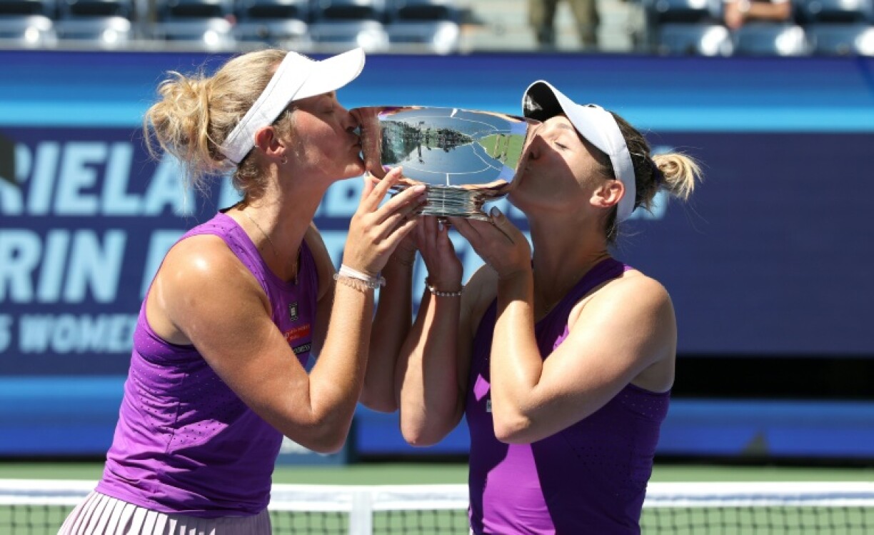 Canada's Gabriela Dabrowski (R) and New Zealand's Erin Routliffe kiss the US Open women's doubles trophy