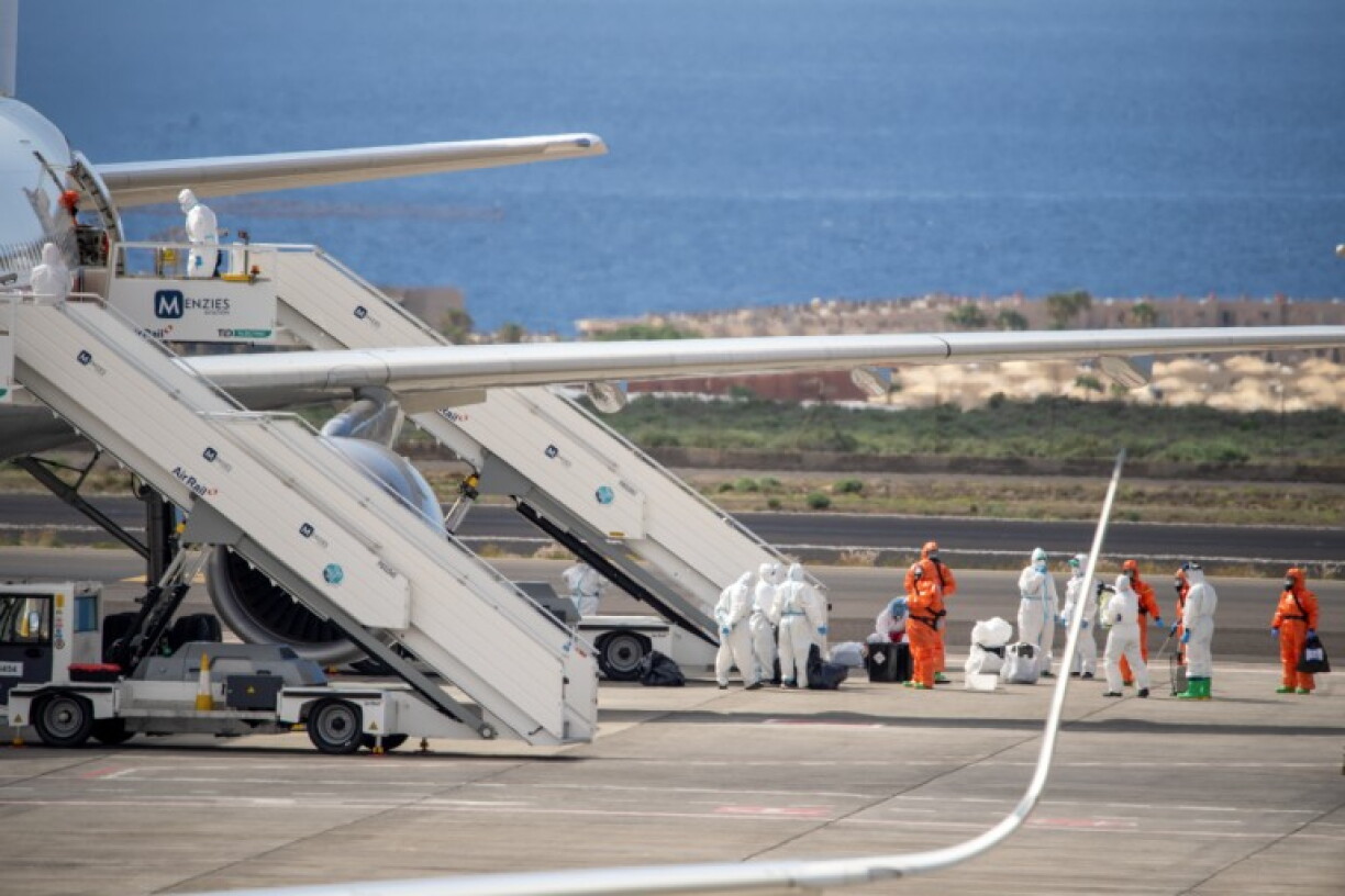 Spanish evacuees wearing white hazmat protective suits board a Spanish air force Airbus A310 plane at the Tenerife Sur-Reina Sofia airport after being evacuated from the Dutch flagged hantavirus-stricken cruise ship MV Hondius on the island of Tenerife in Spain's Canary Islands on May 10, 2026