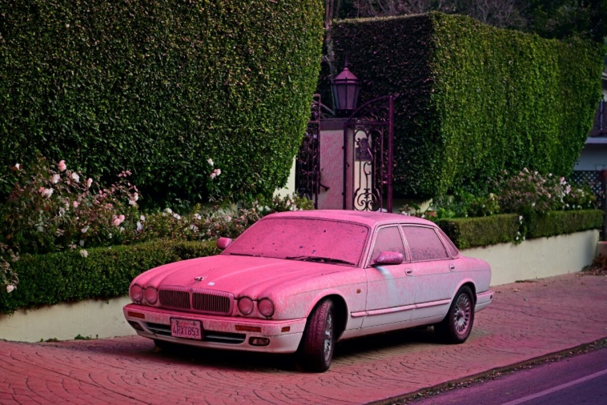 Retardant, usually dropped on less residential areas, now coats cars as well as houses and gardens in residential parts of Los Angeles threatened by the blazes