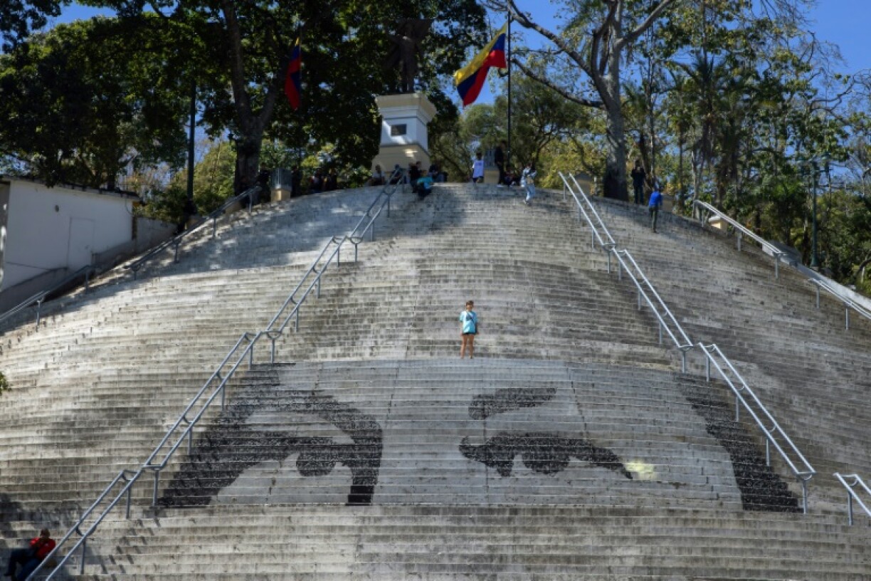 People in Caracas, Venezuela rest on stairs featuring a mosaic portraying the eyes of the country's late president Hugo Chavez during the inauguration of his successor, President Nicolas Maduro, for a third term