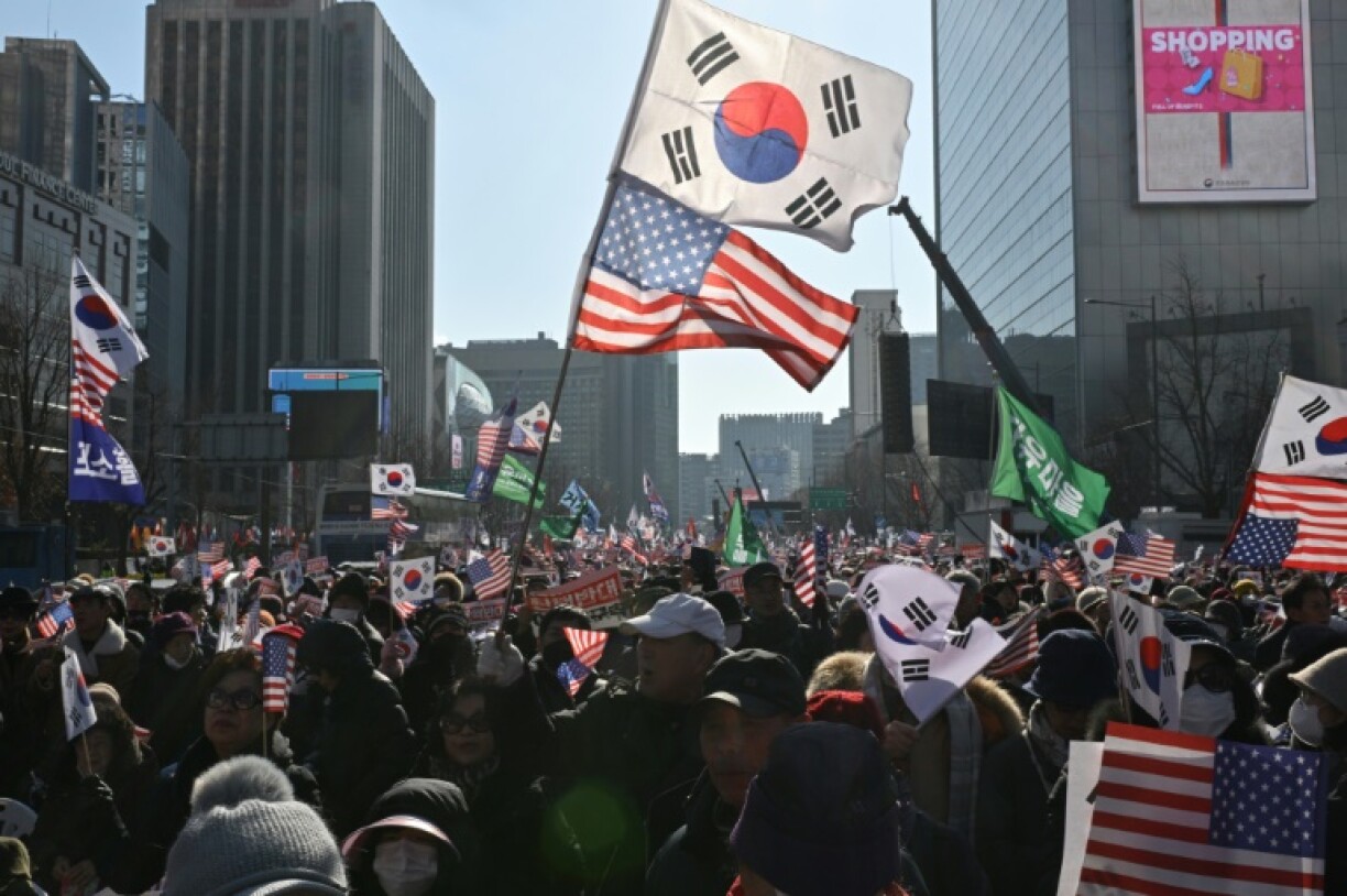 Supporters of President Yoon Suk Yeol wave South Korean and US flags ahead of the second impeachment vote over his declaration of martial law