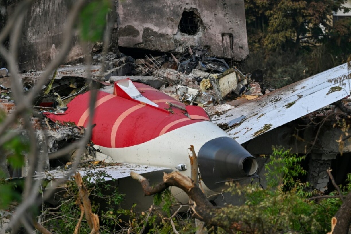 The tail section of the crashed Air India Boeing protruding from a building in Ahmedabad. A preliminary report found the fuel switches had been turned off