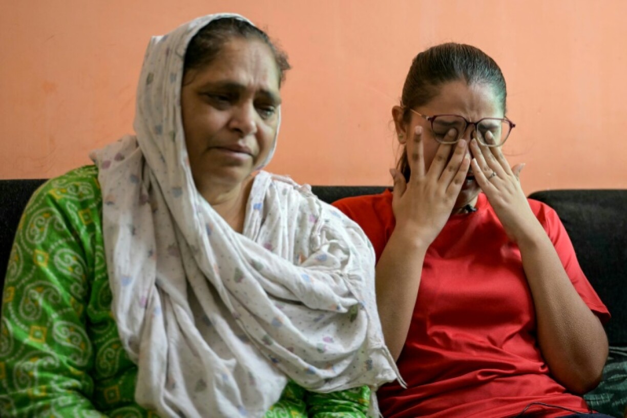 Rinal Christian (R), whose elder brother was on the flight, said her family keeps returning to the hospital but they have been told to wait for his remains