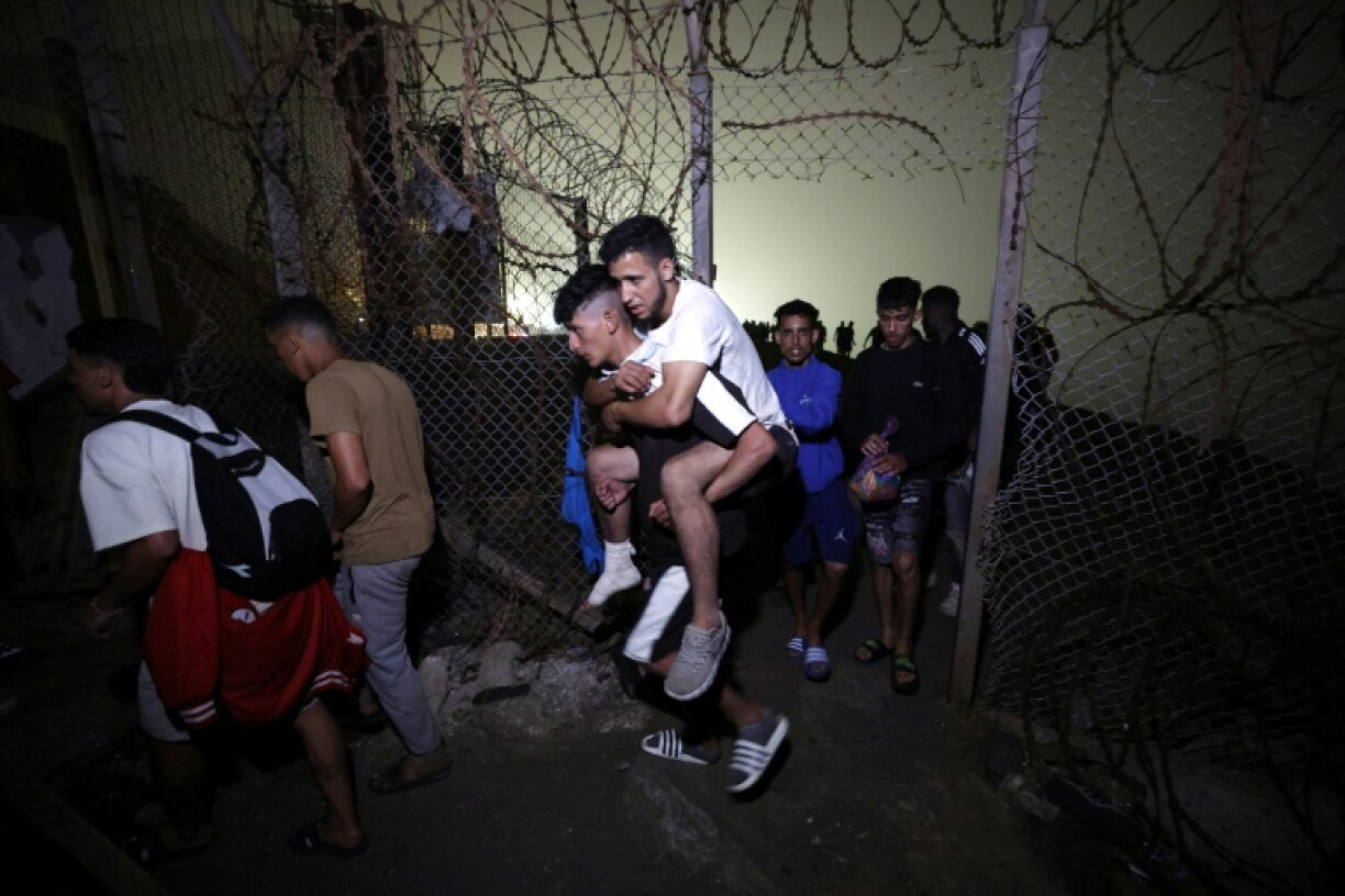 Des migrants regagnent Fnideq, la ville marocaine qui jouxte l'enclave espagnole de Ceuta où des milliers de candidats marocains à l'émigration avaient afflué ces derniers jours, le 1er août 2026 le 1er août 2026 à