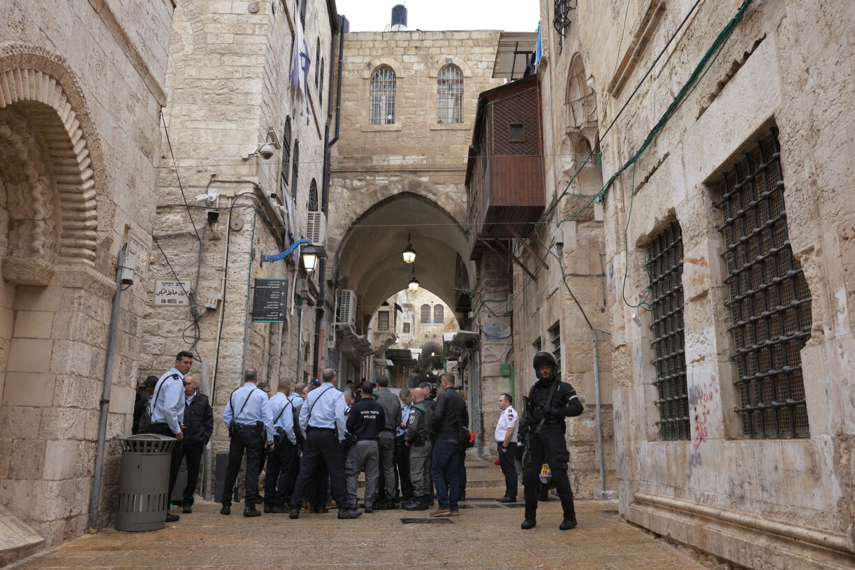 Israeli police and security forces gather at the scene of the shooting in the old city of Jerusalem.