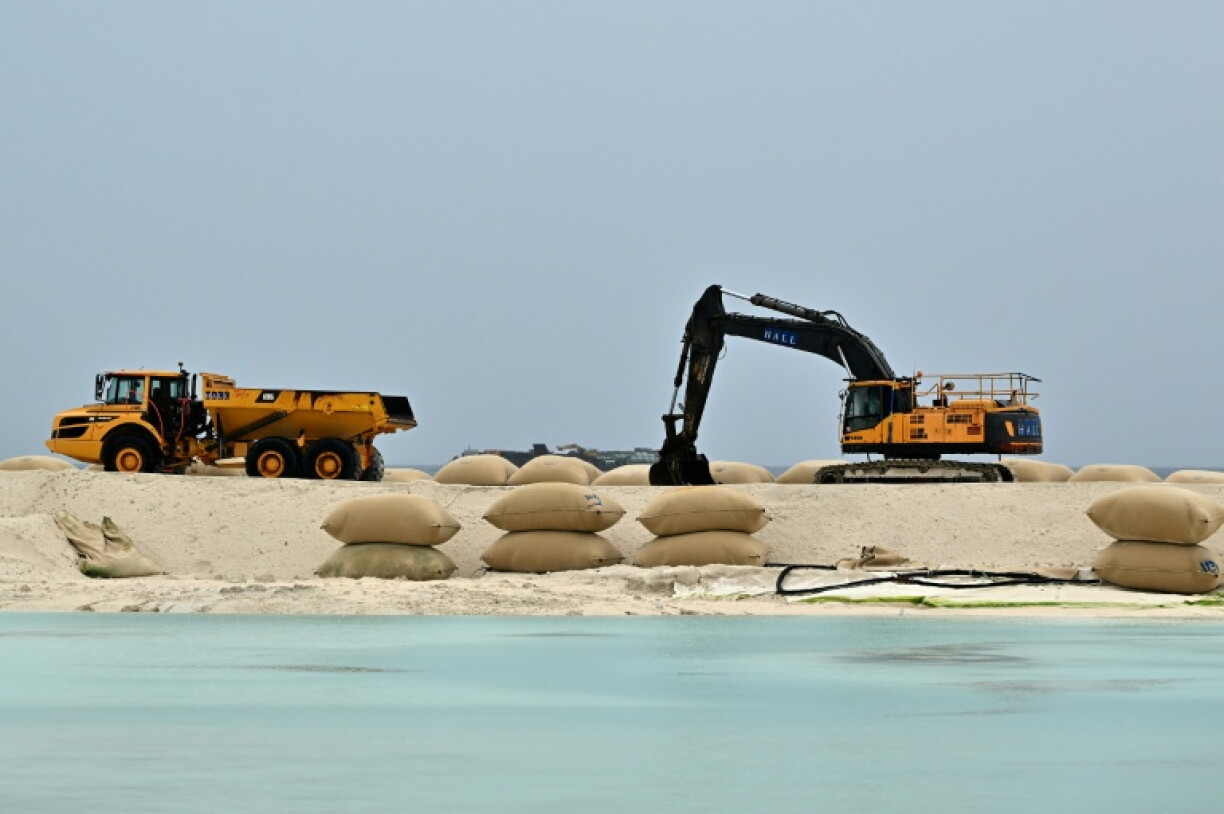 Diggers pile up to help buttress a section of Tuvalu coastline against rising seas.