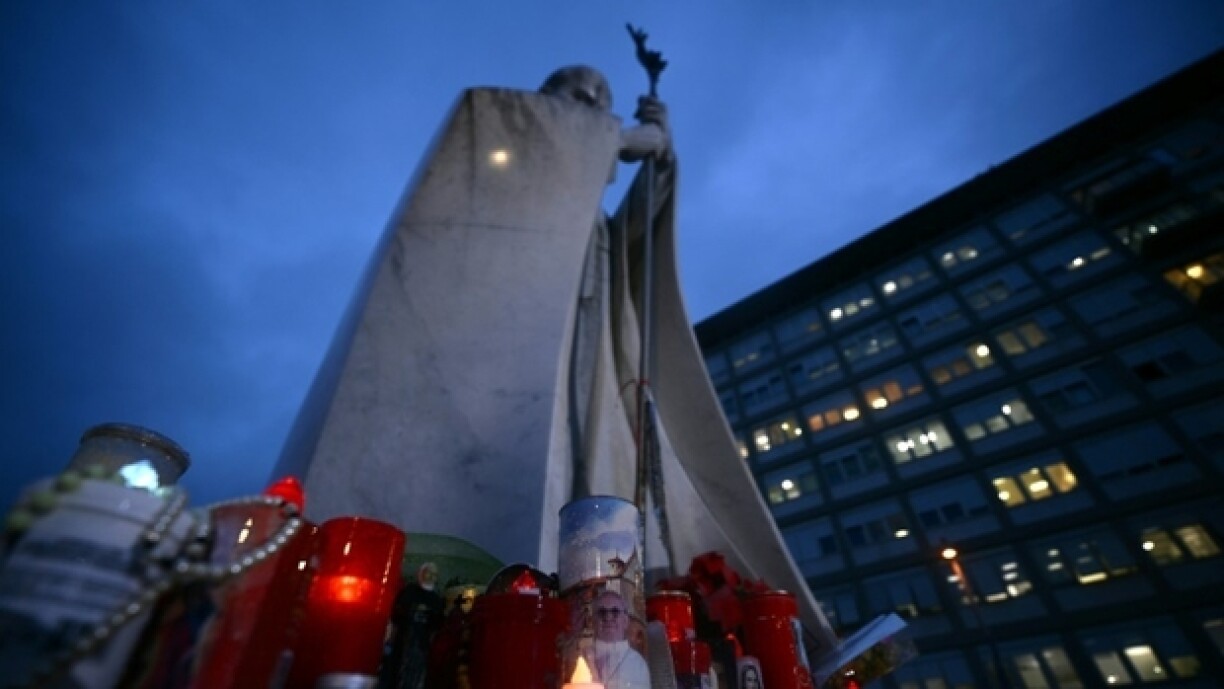 Des bougies sont allumées devant une statue de Jean Paul II à l'extérieur de l'hôpital Gemelli à Rome où le pape François est hospitalisé, le 12 mars 2025