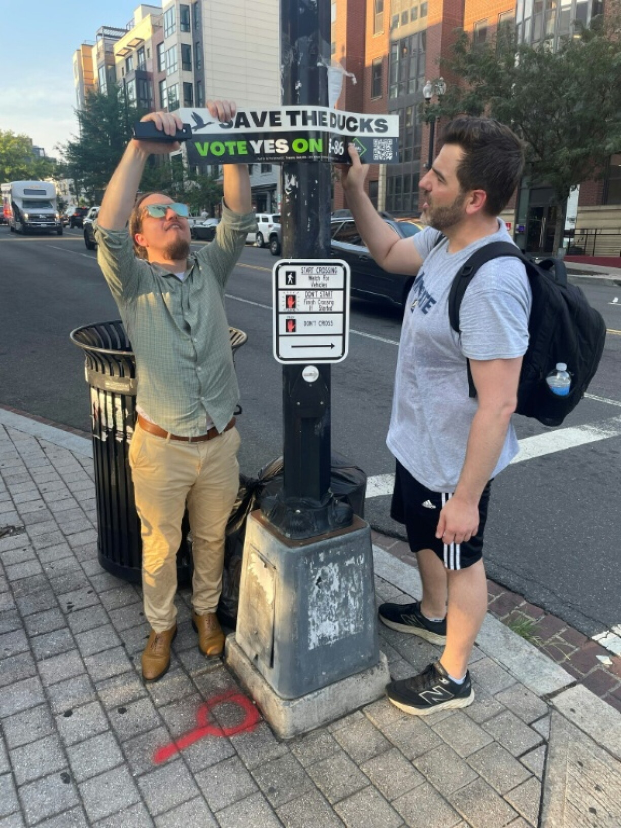 Mike Accardi (L) and James Nance (R), put up signs in Washington DC to raise awareness of the November ballot measure