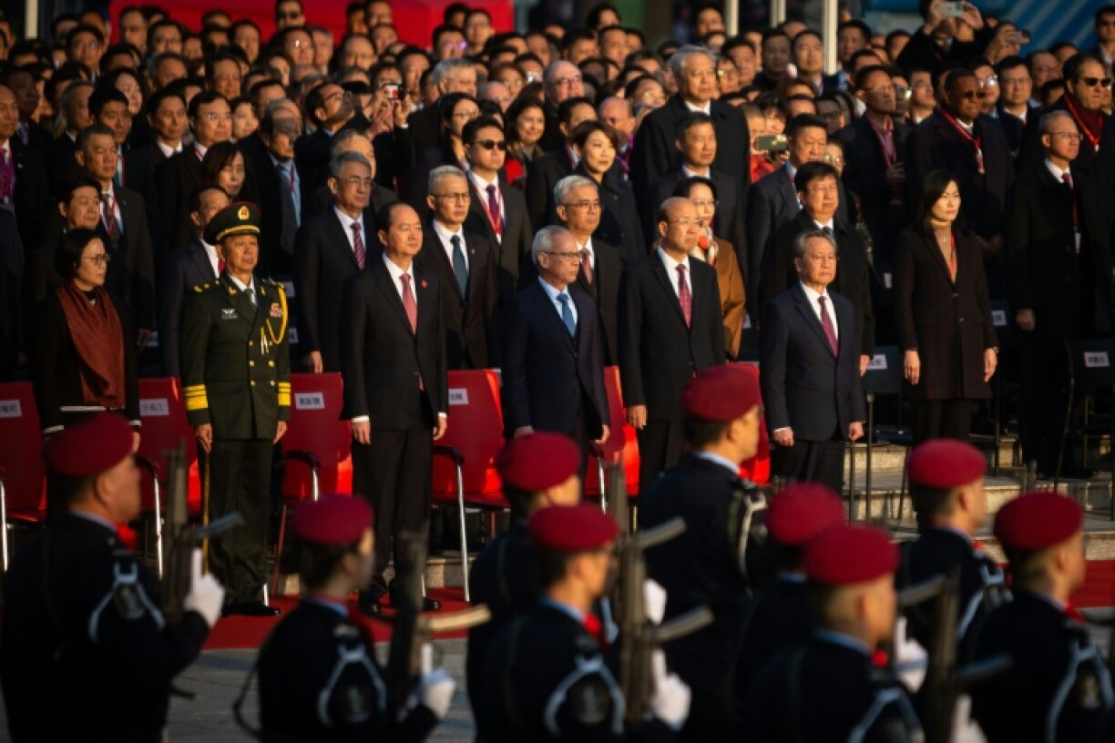 Macau Chief Executive Sam Hou-fai (C) attends a flag-raising ceremony at the Golden Lotus Square marking the 25th anniversary of Macau's handover from Portugal to China