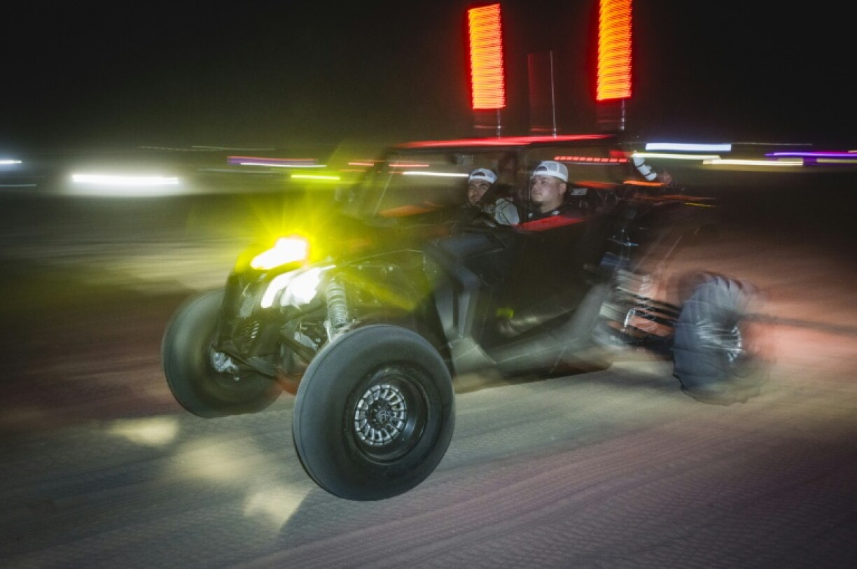 Deux hommes participent à une course nocturne dans leur buggy, près de Somerton, en Arizona, le 18 octobre 2026