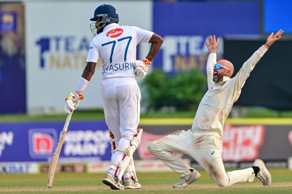 Australia's Nathan Lyon (R) reacts after a delivery during the third day of the second Test