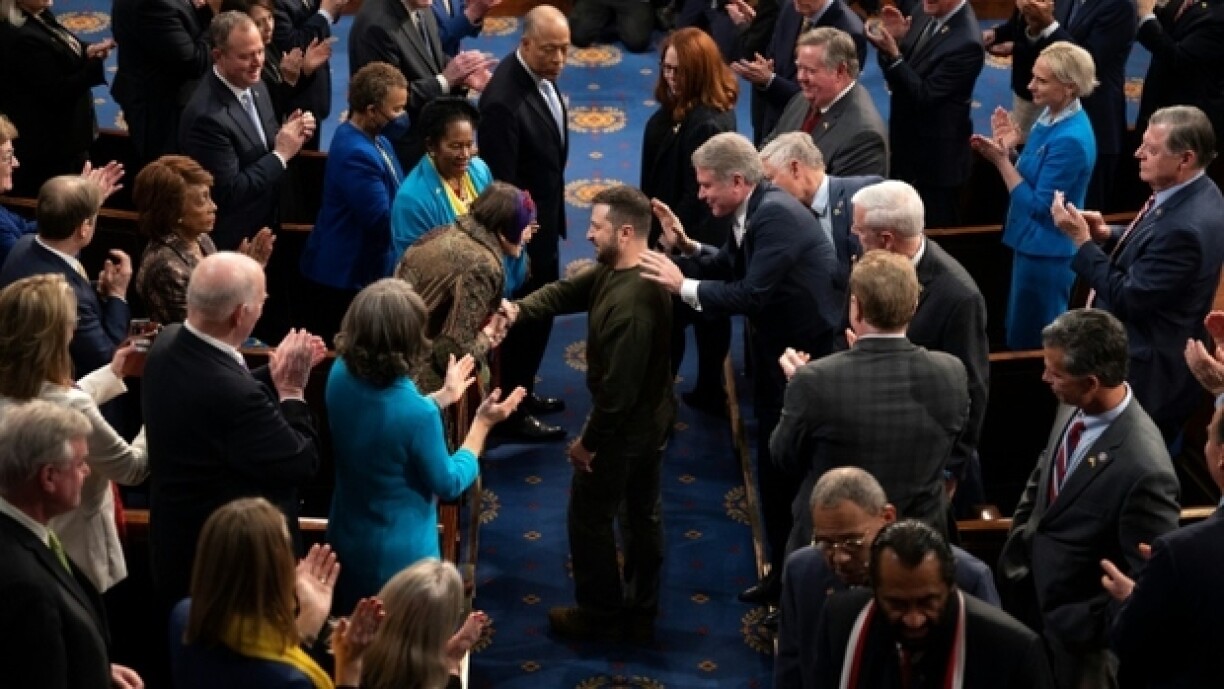 Le président ukrainien Volodymyr Zelensky salué par les membres du Congrès américain, dont des élues en tailleur bleu et écharpe jaune, le 21 décembre 2022 à Washington.