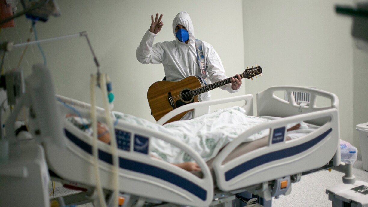 A health worker from the Portuguese charity hospital in Belem, Para State, Brazil, sings and prays for a COVID-19 patient inside the hospital wards and ICU areas as part of Easter celebrations, on April 4, 2021.