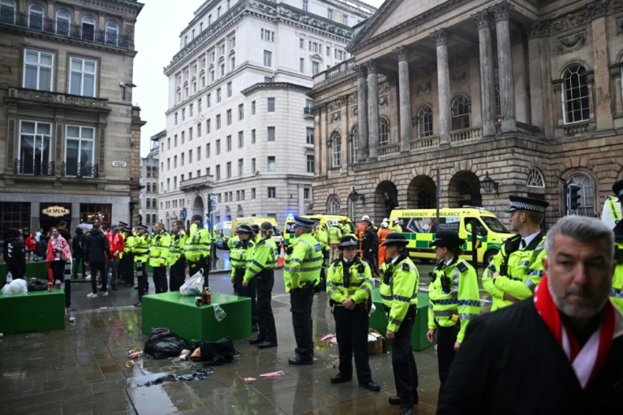 Police stand guard in front of Liverpool Town Hall after a car rammed crowds watching a victory parade for Liverpool's Premier League title win