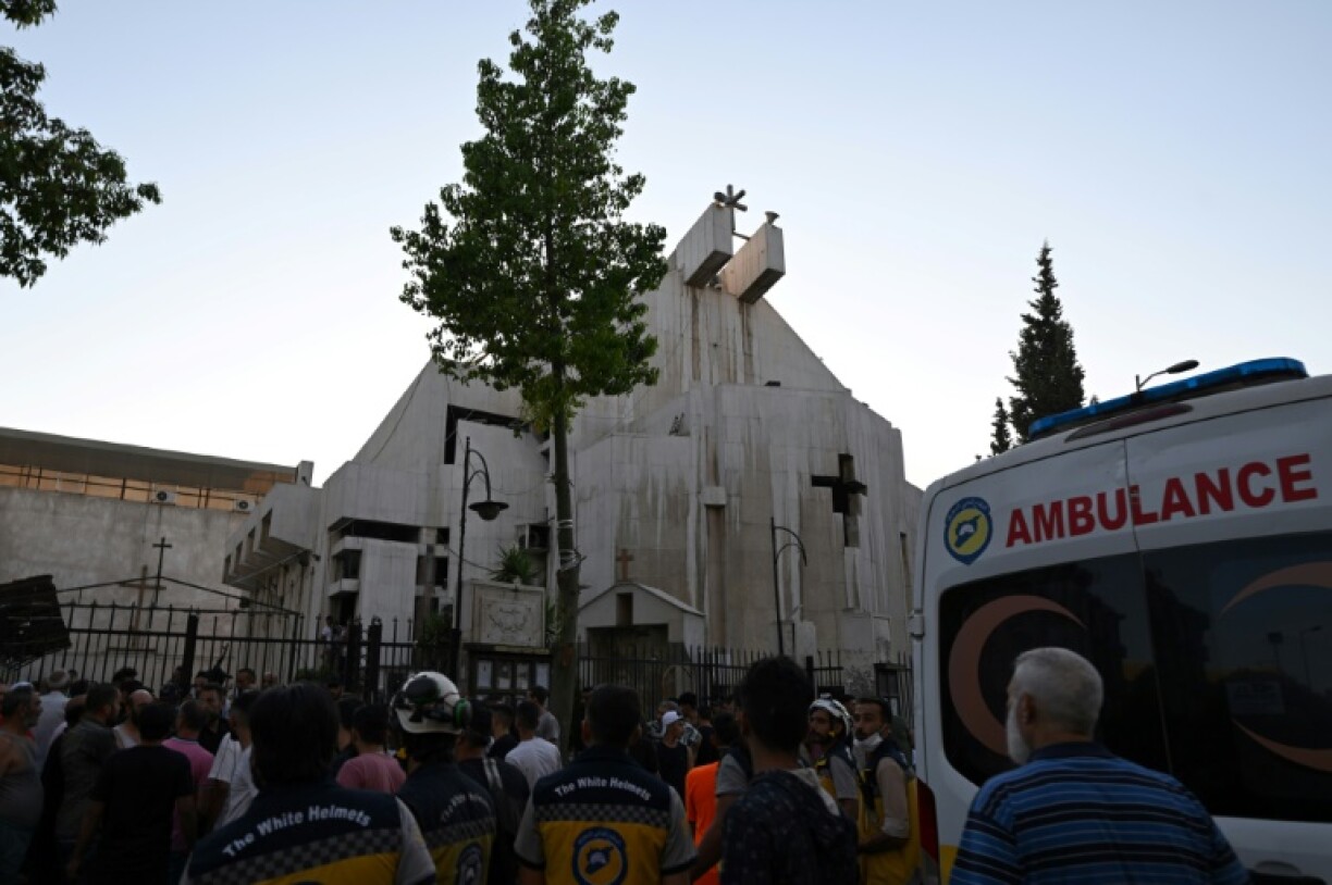 People and rescuers gather at the site of a the suicide attack at Saint Elias church in Damascus on Sunday