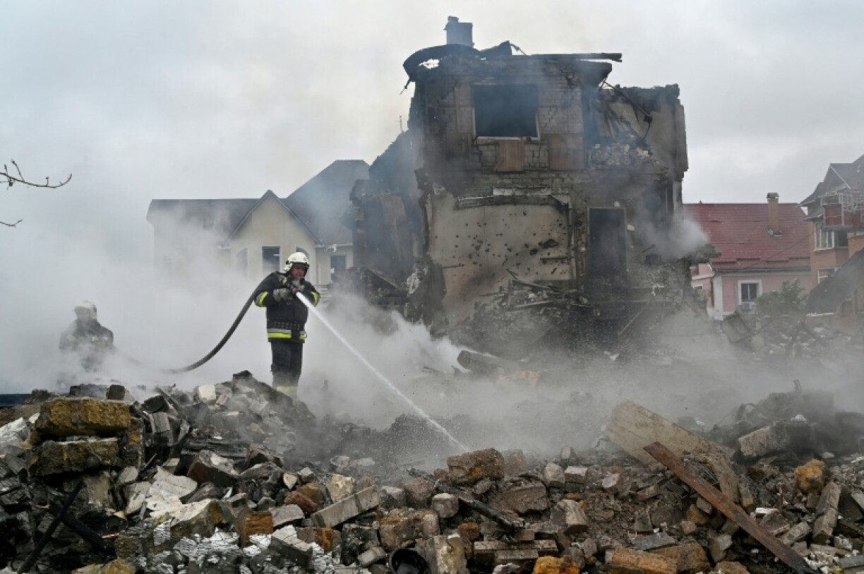 Firefighters extinguish a blaze following Russian strike in the Kyiv region