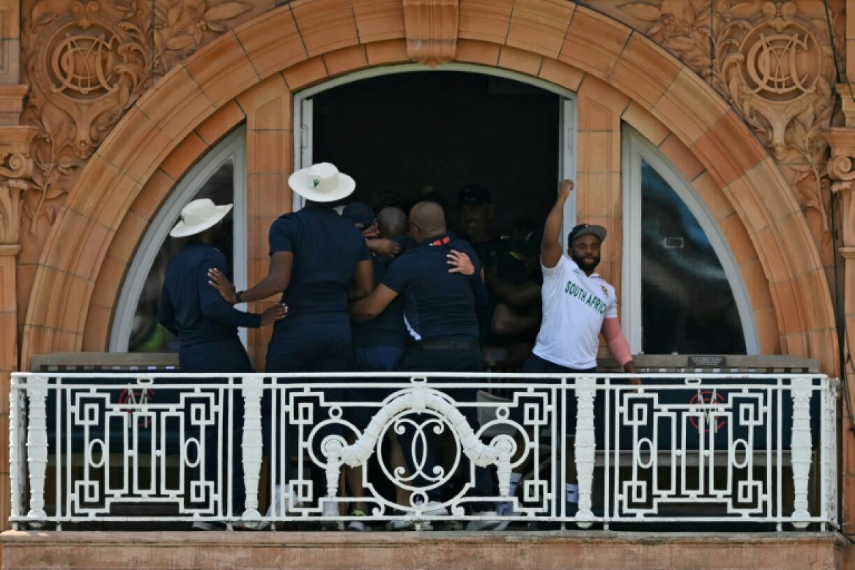 South Africa captain Temba Bavuma (R) celebrates with team-mates on the dressing- room balcony at Lord's following his side's victory over Australia in the World Test Championship final