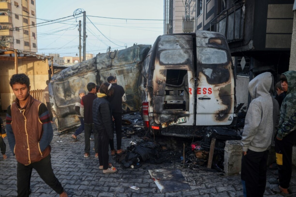 Children check the site of an Israeli strike on a broadcast truck in the Nuseirat refugee camp in the central Gaza Strip, on December 26, 2024