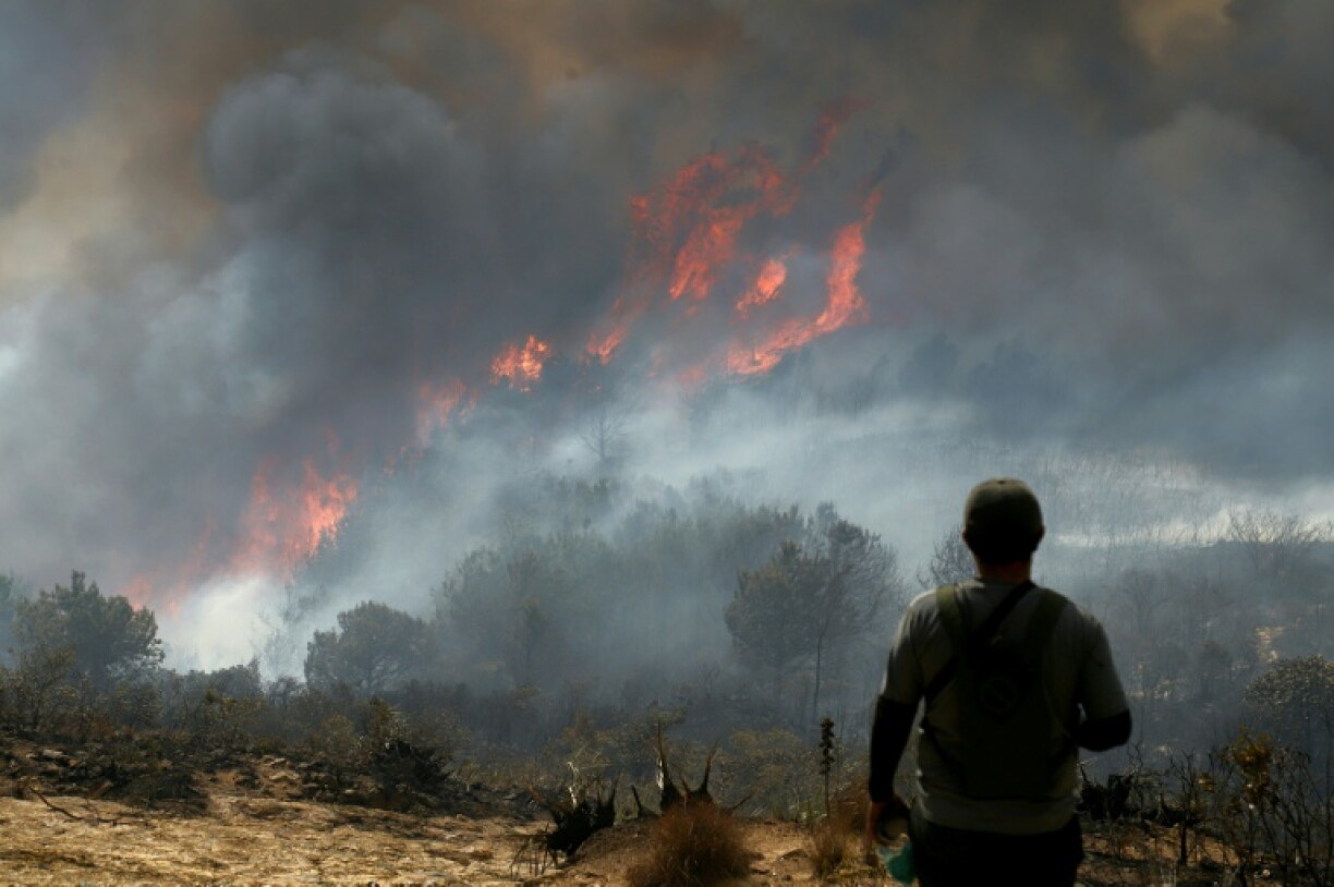Un homme observe un feu de forêt sur la colline de San Marcos, dans la municipalité de Villa de Leyva, le 20 septembre 2026 en Colombie