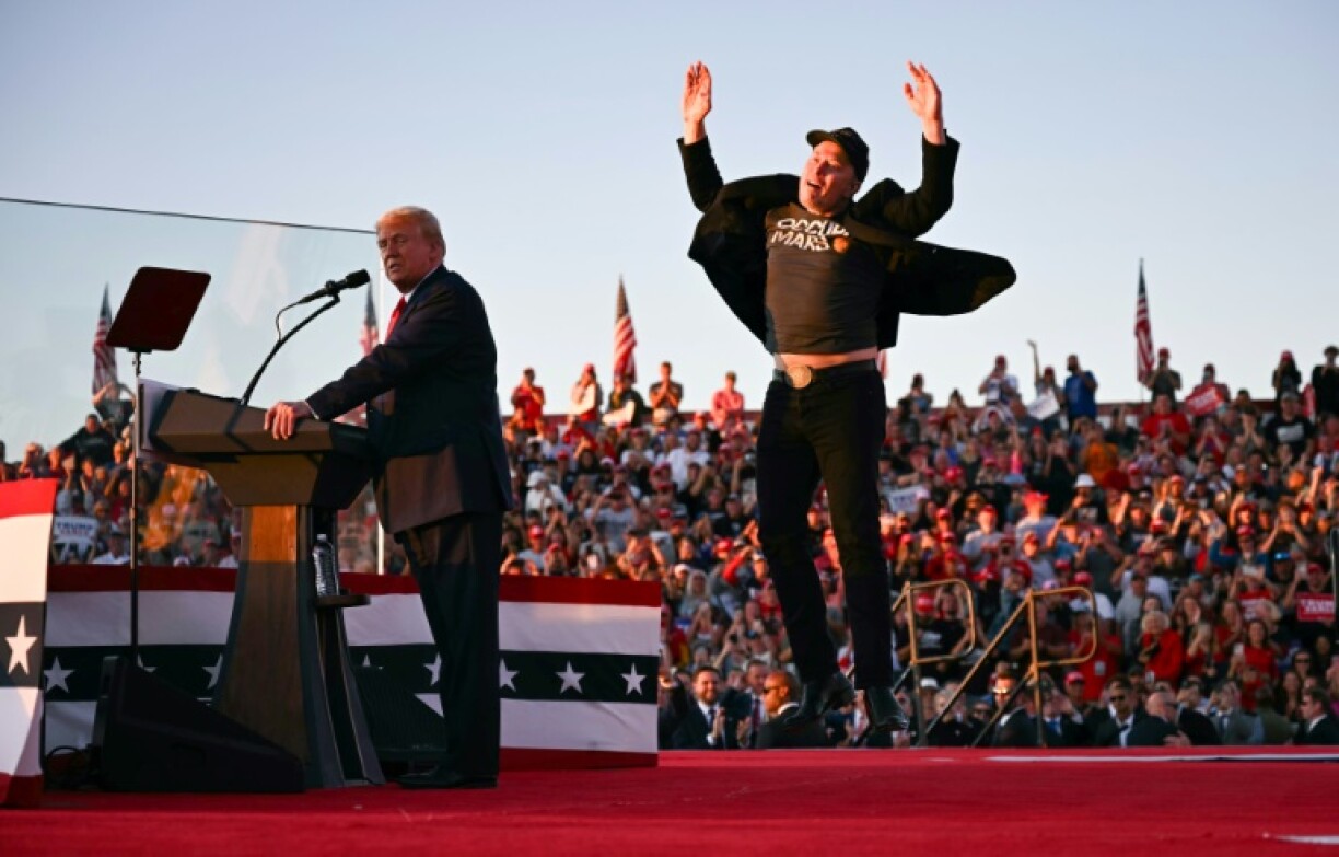 Tesla CEO Elon Musk jumps on stage as he joins Donald Trump, then the Republican candidate for president, during a campaign rally at site of his first assassination attempt in Butler, Pennsylvania in October 2024