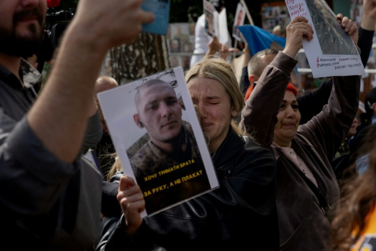 Desperate Ukrainian families hold up photos of missing soldiers as the latest prisoner of war exchange is carried out between Ukraine and Russia