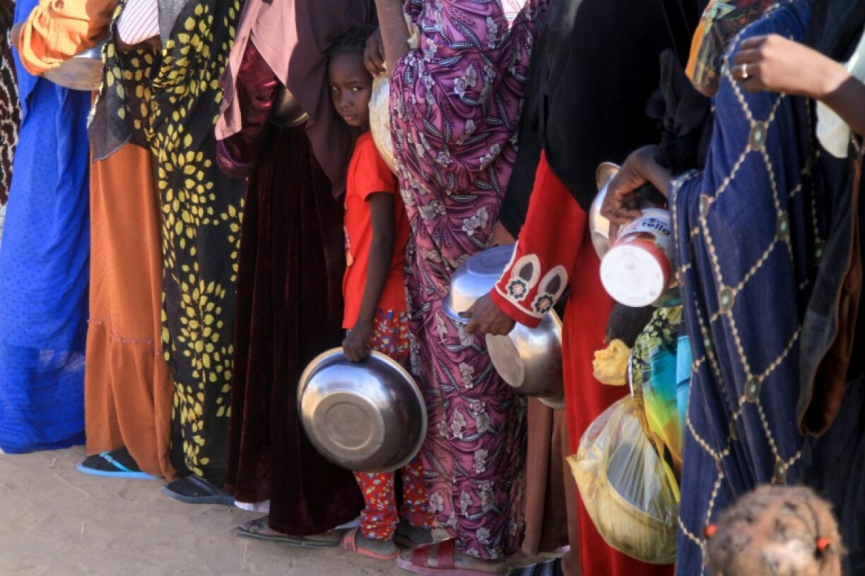 A Sudanese girl who fled El-Fasher lines up with others to receive a free meal at the Al-Dabbah camp
