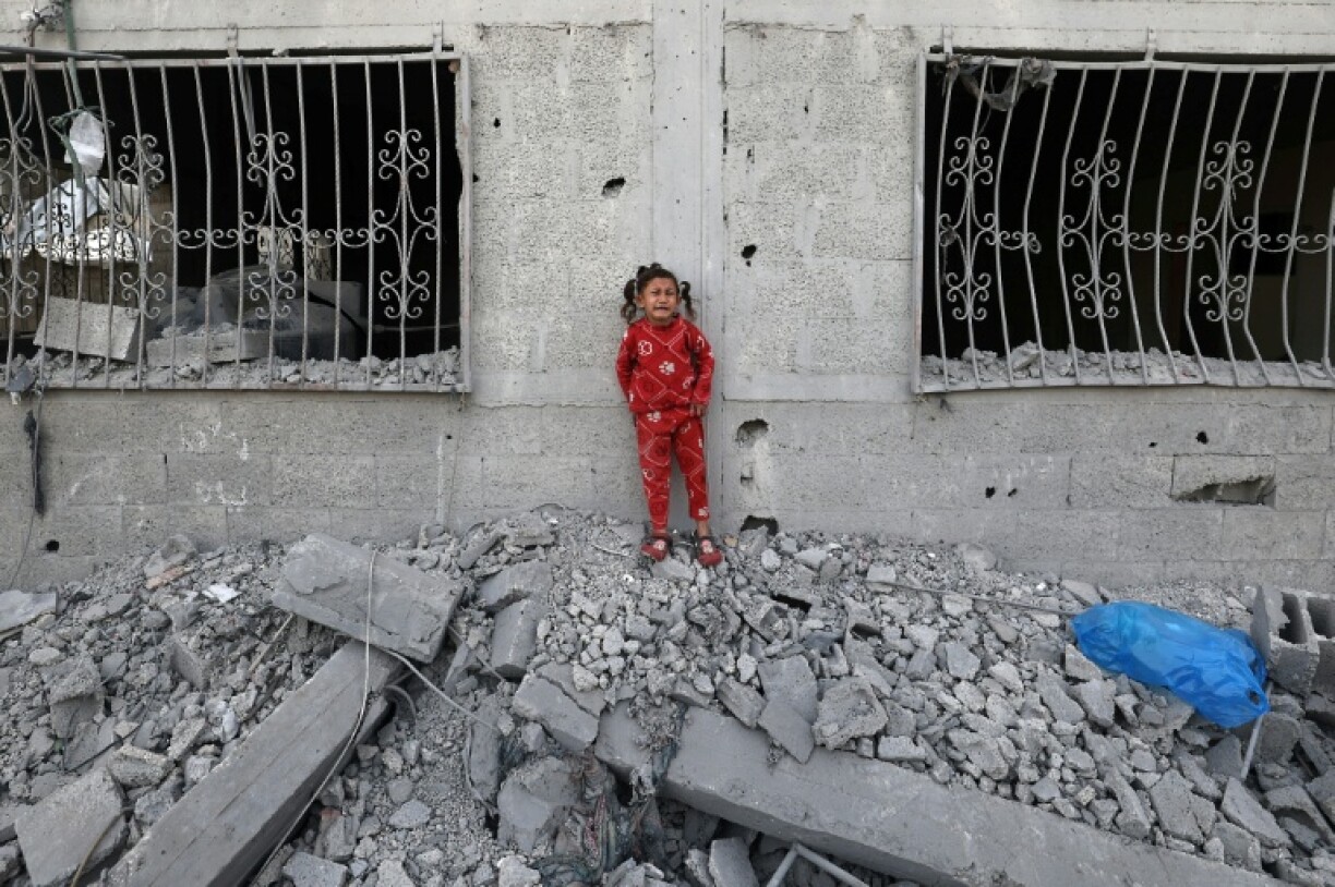A crying Palestinian girl stands over the debris of a house hit by an Israeli strike in the south Gaza city of Khan Yunis on Wednesday.