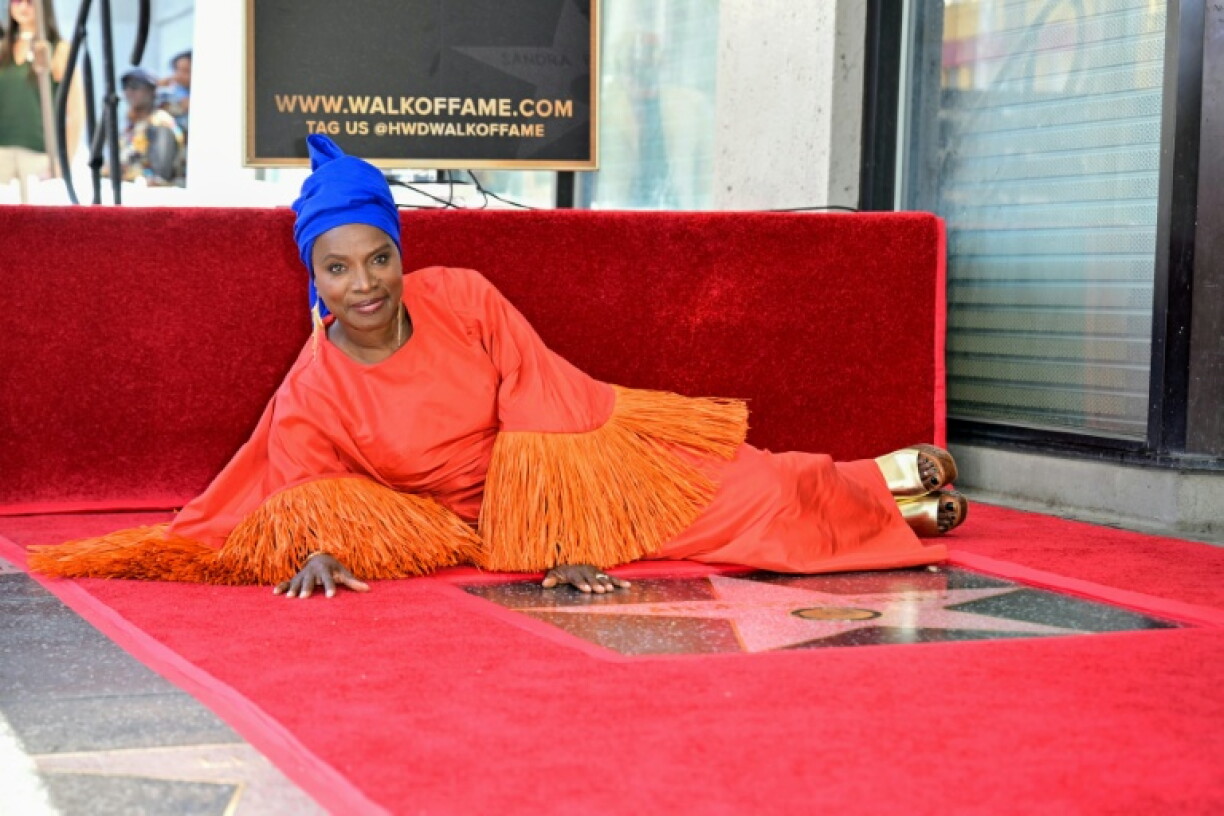 La musicienne Angélique Kidjo pose aux côtés de son étoile sur le "Walk of Fame", dans le quartier d'Hollywood à Los Angeles, le 18 août 2026