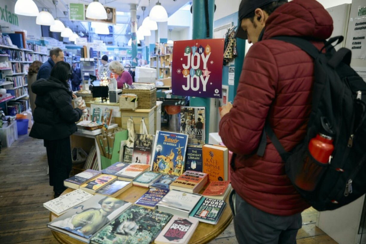 Customers browse a display of books, saying buying second-hand gifts not only helps stretched budgets but is also good for sustainability