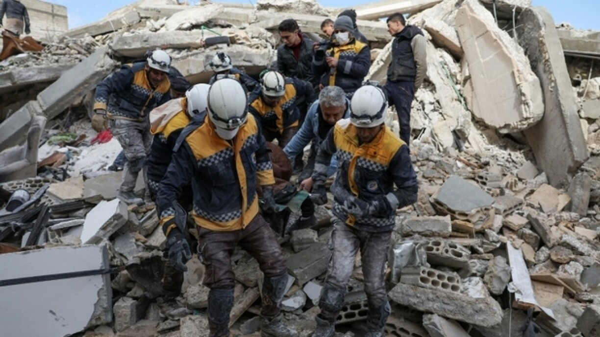 Les Casques blancs, les secouristes des zones rebelles en Syrie, transportent une victime du séisme dans le village d'Azmarin, le 7 février 2023.