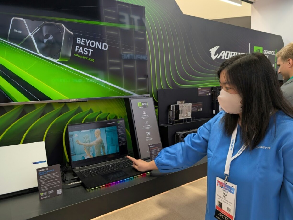 Mia Qu of Gigabyte Technology gestures to a gaming laptop enhanced with a superfast Nvidia chip as AI capabilities head for personal computers during the Consumer Electronics Show (CES) in Las Vegas, Nevada on January 9, 2025