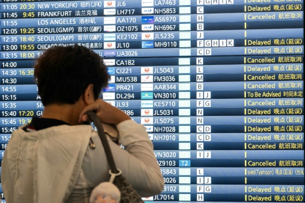 Un panneau annonçant l'annulation de vols et des retards en raison de la tempêtre tropicale Jangmi, à l'aéroport de Tokyo le 3 juin 2026