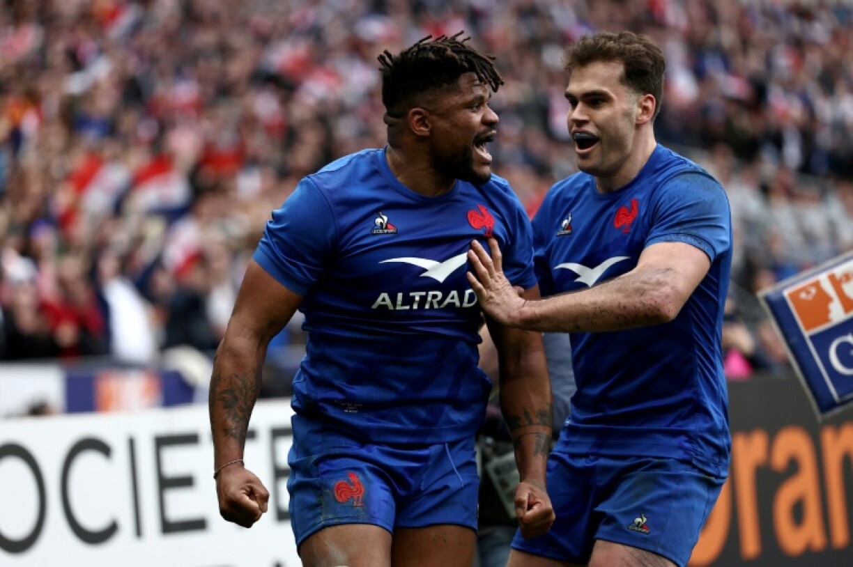 Le centre français Jonathan Danty (à gauche) célèbre avec l'ailier Damian Penaud (à droite) son essai incrit durant la victoire contre le pays de Galles (41-28) lors de la dernière journée du Tournoi des Six nations 2023, le 18 mars au Stade de France, dans le nord de Paris