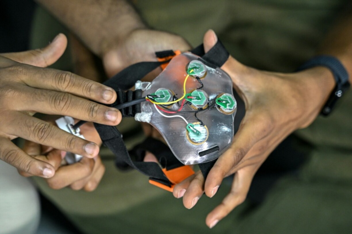 Akash Kulgod (d), cofondateur de Dognosis, tient un dispositif d'interface cerveau-machine (ICM), le 28 juillet 2026 à Kempohalli, en périphérie de Bangalore, en Inde