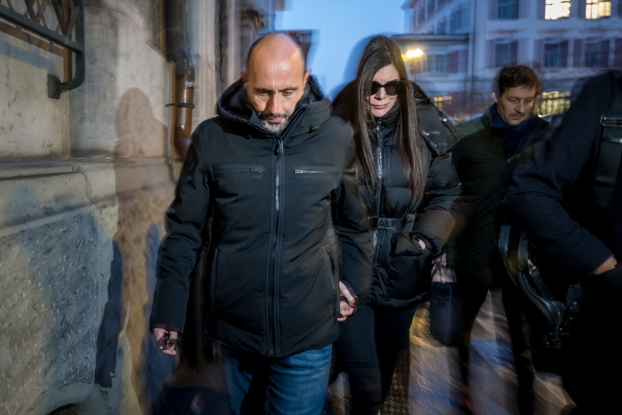 Owners of Le Constellation bar Jacques Moretti (L) and Jessica Moretti (rear R) arrive for a hearing at the Office of the public prosecutor of the Canton of Valais, in Sion, on January 9, 2026. The French couple, facing charges of manslaughter by negligence, bodily harm by negligence and arson by negligence, have been called in for questioning after 40 people, most of them teenagers, were killed, while 116 were injured in a fire that ripped through a bar in the luxury Alpine ski resort of Crans-Montana on New Year's Eve.