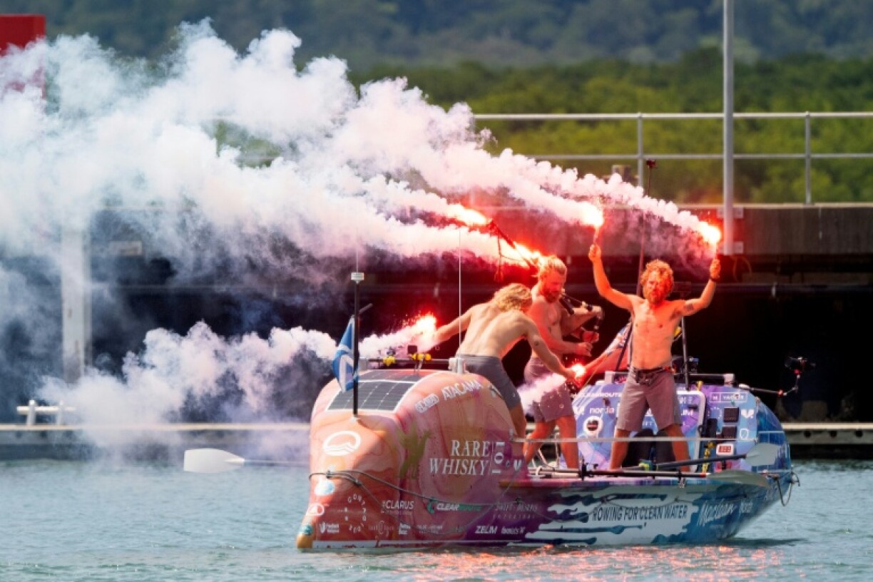 Three Scottish brothers (L-R) Lachlan, Jamie and Ewan MacLean celebrate as they arrive in Cairns, Australia, after a record non-stop row across the Pacific