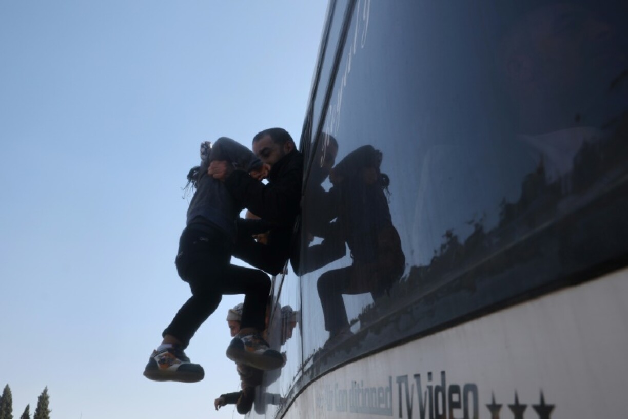A former Palestinian prisoner, released as part of the sixth hostage-prisoner exchange, hugs a child upon arriving in Khan Yunis