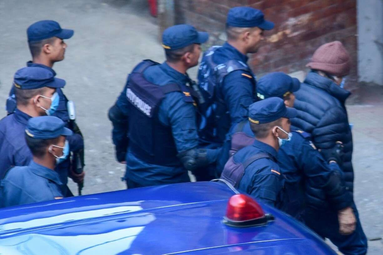 Des policiers escortent le tueur en série français Charles Sobhraj (d) vers les bureaux de l'immigration, avant son expulsion vers la France, le 23 décembre 2022 à Katmandou, au Népal