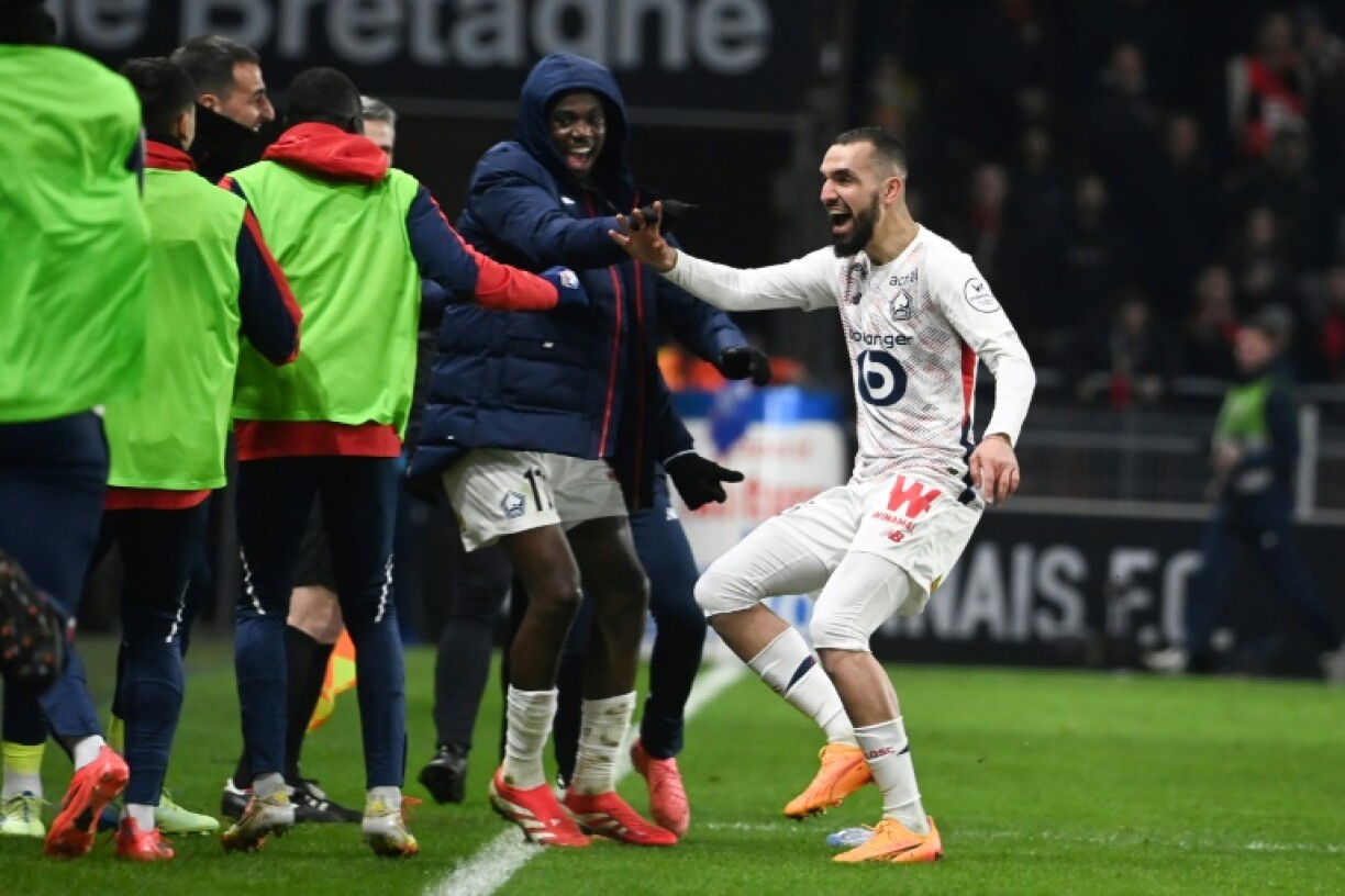 Nabil Bentaleb runs to the sideline to celebrate his comeback goal with Lille substitutes and coaches