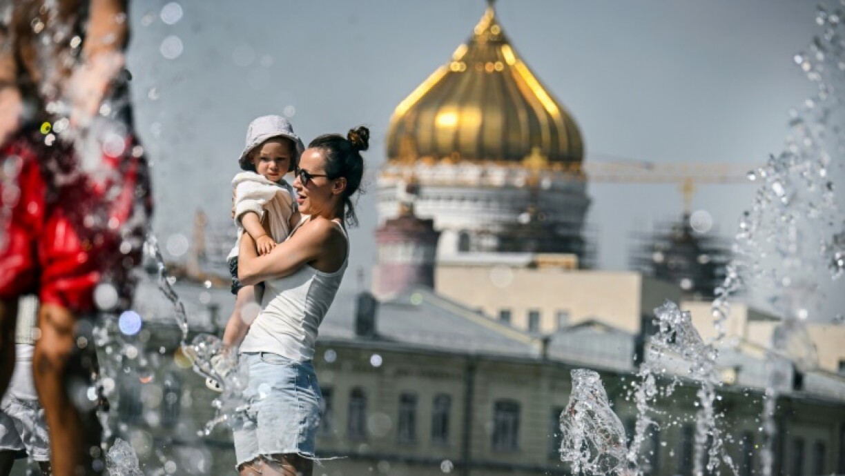 People cool off in front of Moscow's Christ the Saviour Cathedral, as the Russian capital sweltered under record heat