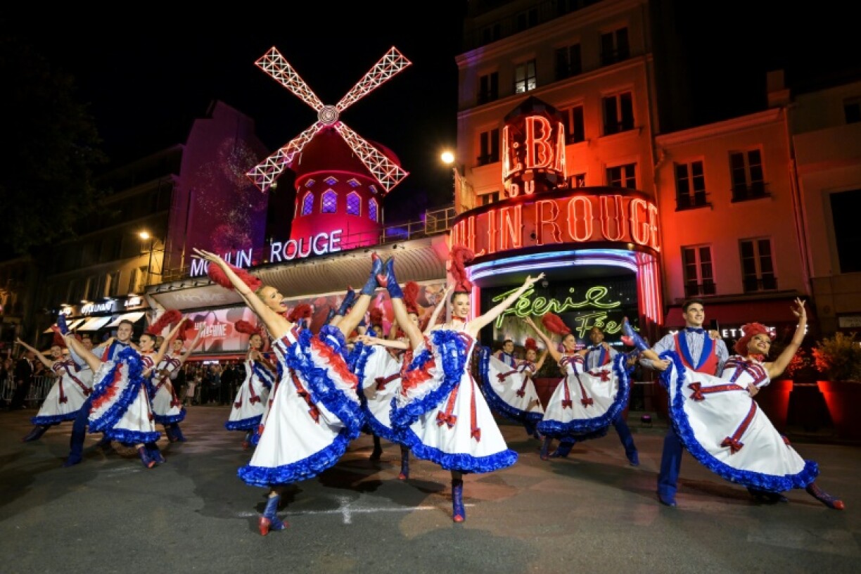 Des danseuses et danseurs devant le cabaret du Moulin Rouge lors de l'inauguration de ses nouvelles ailes, le 5 juillet 2024 à Paris