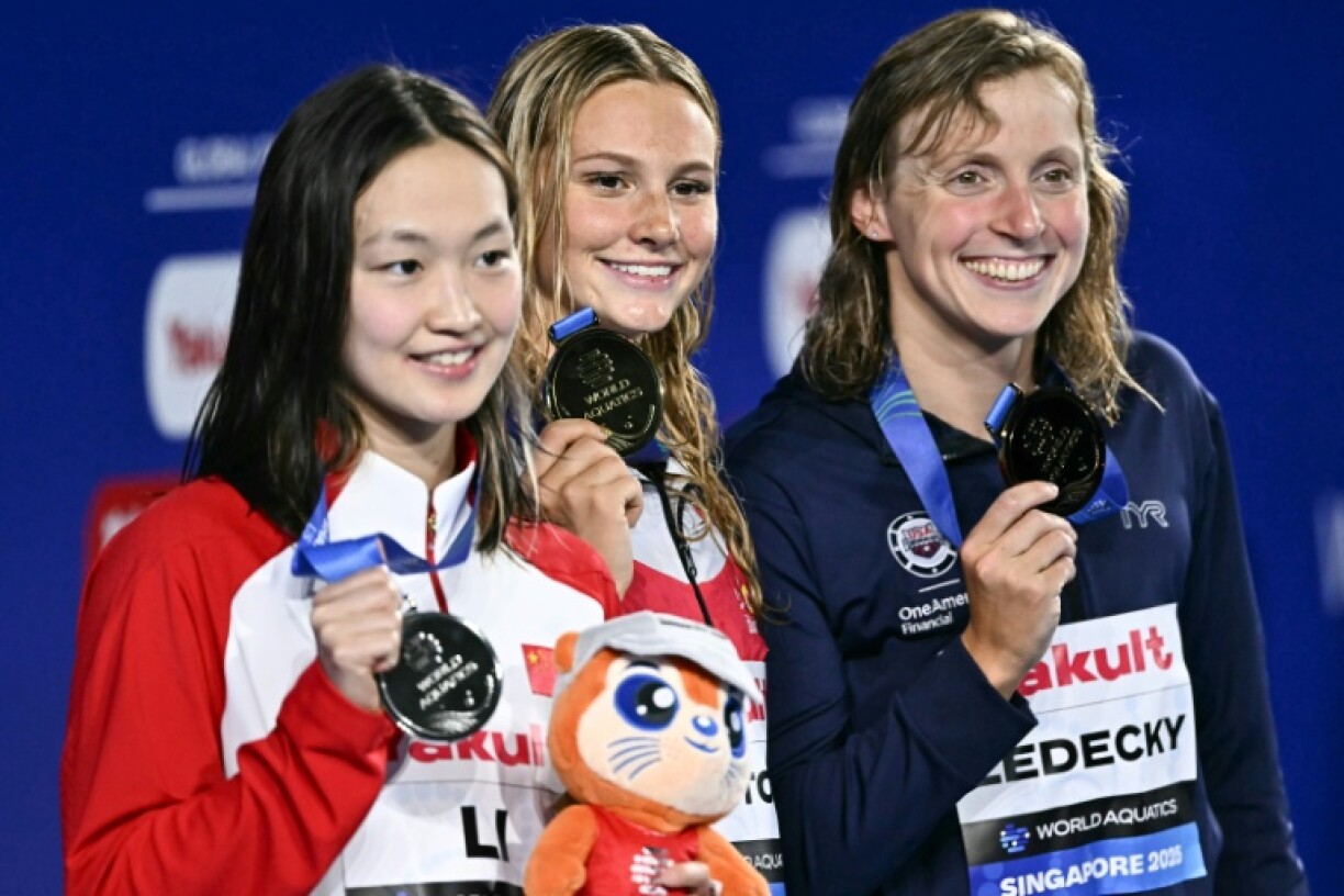 (L-R) Silver medallist Li Bingjie, gold medallist Summer McIntosh, and bronze medallist Katie Ledecky celebrate on the podium after the women's 400m freestyle swimming event