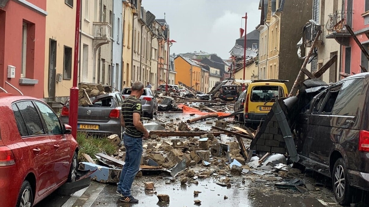 August 2019: E Mann steet an enger vum Tornado zerstéierter Strooss.