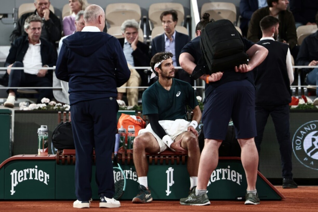 Lorenzo Musetti (C) briefly received treatment on his left thigh before being forced to retire