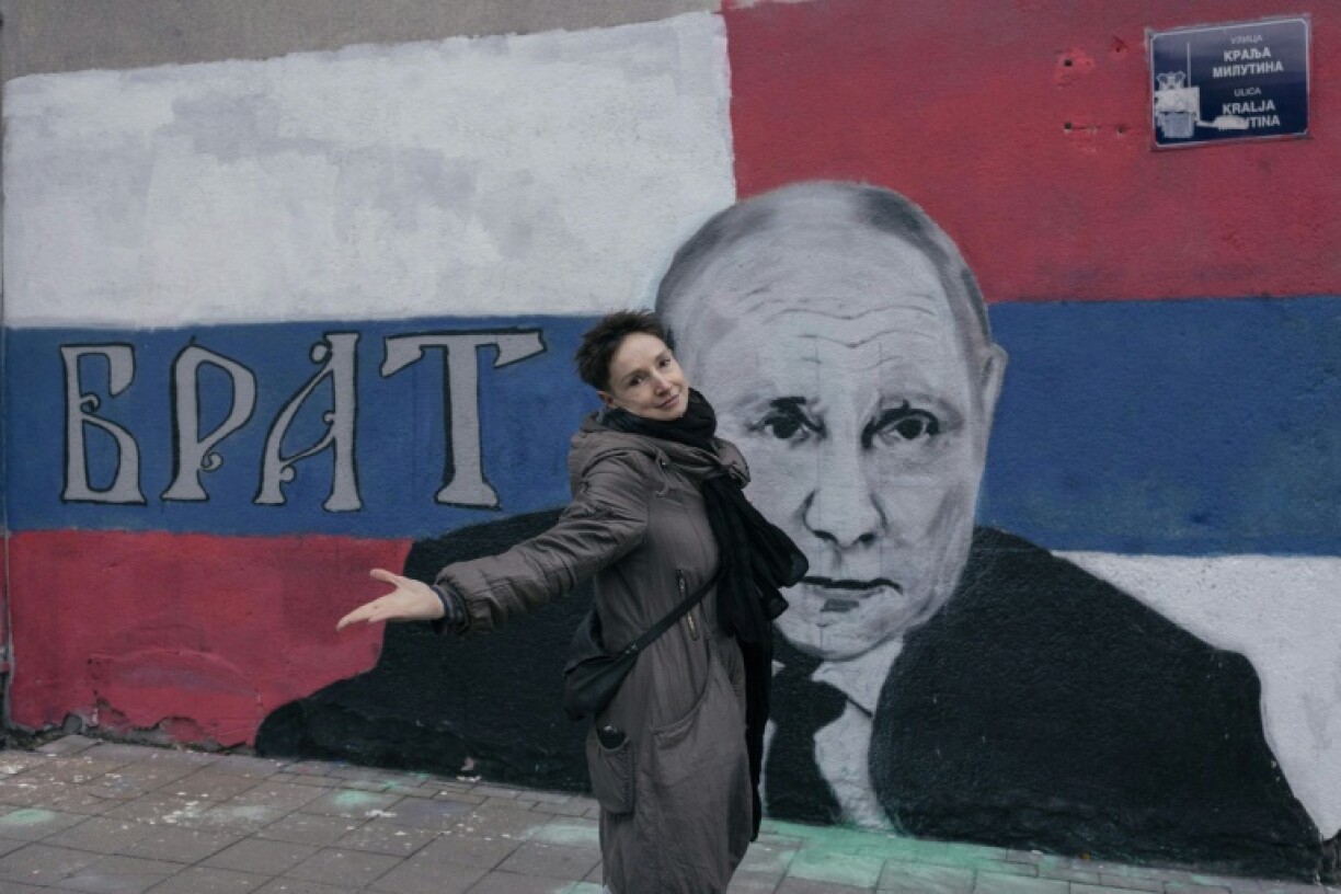 Marina devant une fresque murale du président russe Vladimir Poutine, le 17 mars 2022 à Belgrade, en Serbie